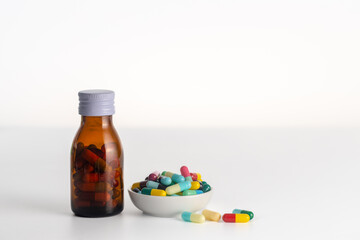1 bottle of medicine without labels  and medicine cup on a white background