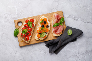 Sandwich set of bruschetta with juicy tomatoes, cheese and prosciutto