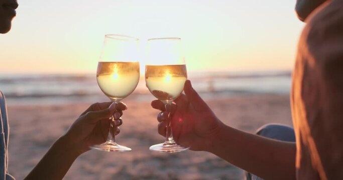 Sunset, beach and hands of couple with wine for love, relax or celebrate anniversary date. Closeup, people and cheers at sea with alcohol drink, champagne or celebration of vacation, holiday or party