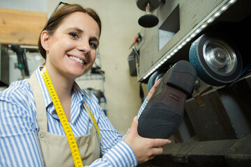 a female shoemaker repairs shoes