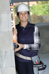 woman using a spirit level at construction site