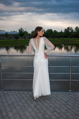 Beautiful bride woman in wedding dress on sunset outdoor