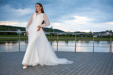 Obraz premium Beautiful bride woman in wedding dress on sunset outdoor
