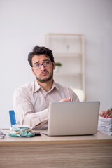 Young male accountant working in the office