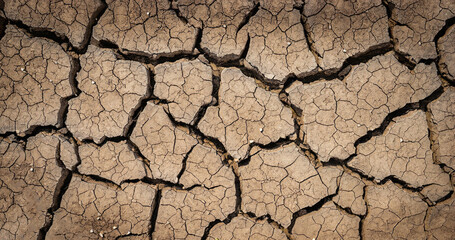 Cracked ground background in the top view for graphic design or wallpaper. Natural texture with the concept of drought and death. Empty space with abstract pattern in vintage style.