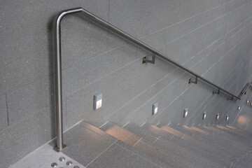 Stainless steel handrail on the office stone wall.