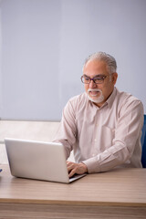 Old male teacher in front of whiteboard