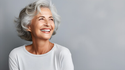 Beautiful senior model with white hair, laughing and smiling, reflecting health and beauty with great skin and teeth