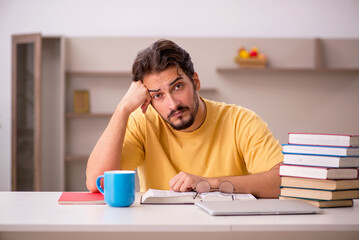 Young male student preparing for exams at home