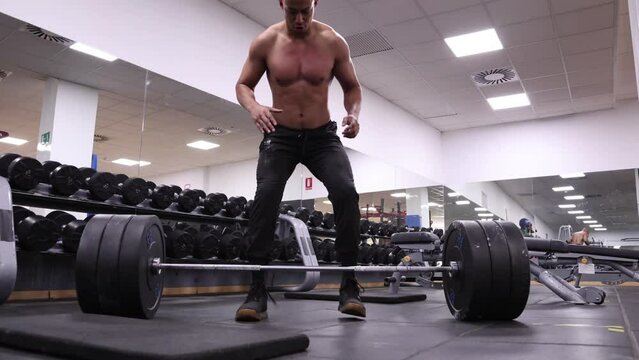 Low angle view of a man deadlifting in a gym