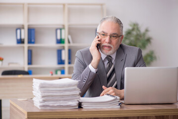 Naklejka premium Old male employee and too much work in the office