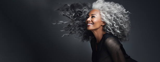 Beautiful black woman with smooth healthy face skin. Gorgeous aging mature woman with long gray hair and happy smiling. Beauty and cosmetics skincare advertising concept