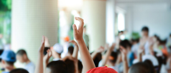 Group of happy children with their hands up