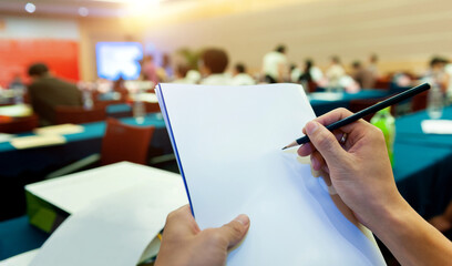 People writing on document at a business seminar