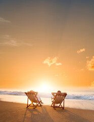 Young couple sunbathing on beach chair
