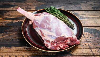 Whole fresh Raw goat shoulder meat on a plate. Dark wooden background. Top view. © Uuganbayar