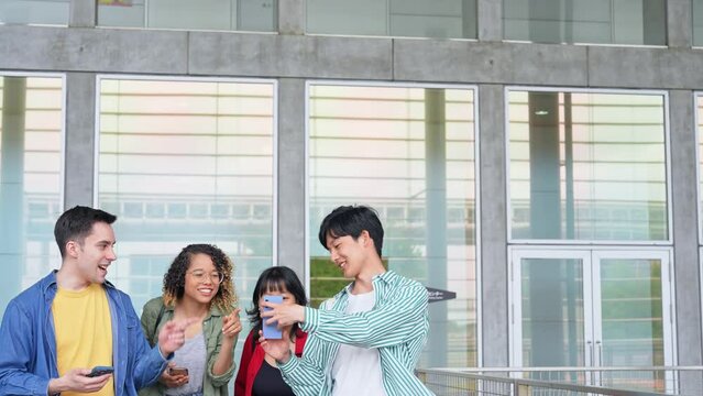 スマホを見ながら歩く多国籍若者グループ