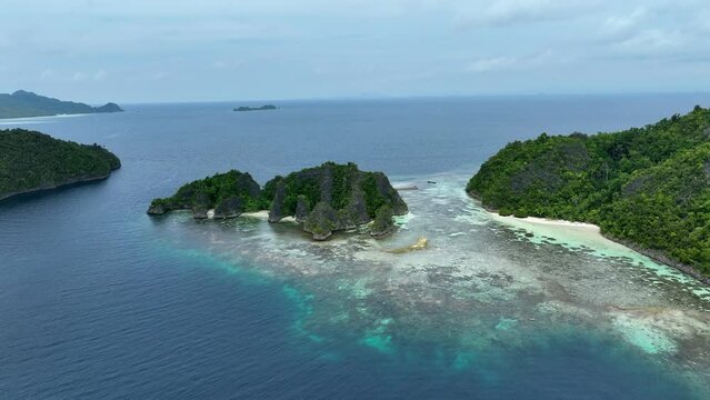 Aerial Forward Over Green Islands On Blue Sea Against Sky - Raja Ampat, Indonesia