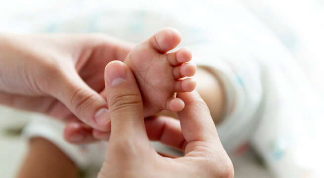 Close up of doctor hands massaging baby foot