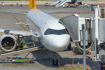 View of the nose and cockpit of the aircraft and the docking gangway air bridge. Maintenance and...