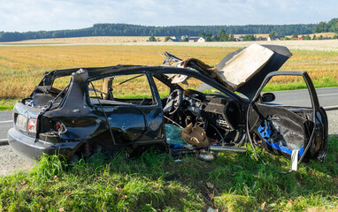 burnt out wrecked car on the side of the road