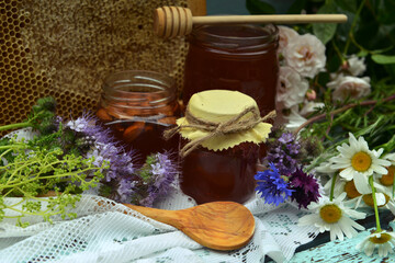 Obraz na płótnie Canvas Still life with natural honey in jar, dipper, flowers and stick on wooden background outside. Countryside summer rural background, vintage concept, healthy food