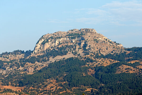 Evening view of a limestone hill and juniper forest at the foot of the hill as part of the central Taurus Mountains in the Arslankoy village of Mersin province.