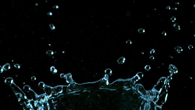 Super slow motion of splashing water crown shape on black background. Filmed on high speed cinema camera, 1000fps.