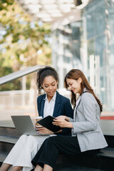 Two successful business colleagues having a discussion while talking on street in city Outside...