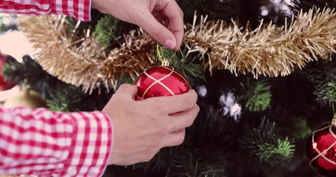 Woman hanging new year ball on christmas tree 4k movie. Celebrating new year and christmas concept