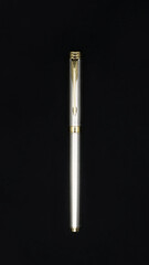 top view of a limited edition silver color business pen made of stainless steel isolated in a black background