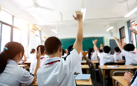 Group of raised hands in class of middle school