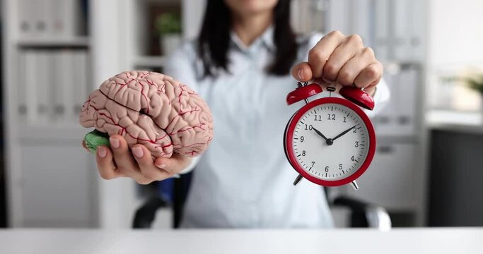 Woman holding red alarm clock and artificial brain model 4k movie slow motion. Sleep and wake time concept