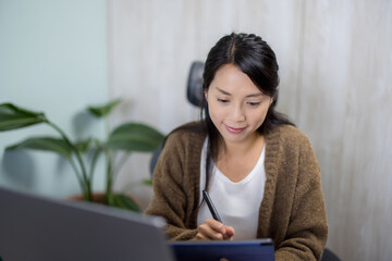 Woman work on laptop with tablet computer at home office