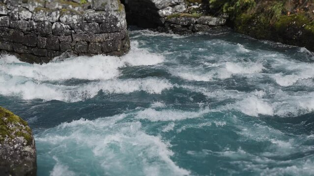 Graceful chaos: Slow-motion capture of crashing, whirling water attacking the stone bridge.