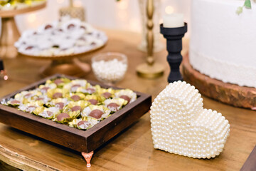 Obraz na płótnie Canvas trays of chocolate brigadeiros on a table decorated with flowers for a wedding