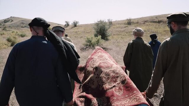 Muslim funerals during the war in Afghanistan. Pashtun men stand.