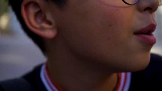 a small asian a boy beatboxing in a close up short