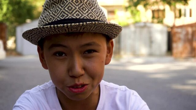  a small asian a boy with cap beatboxing in a street