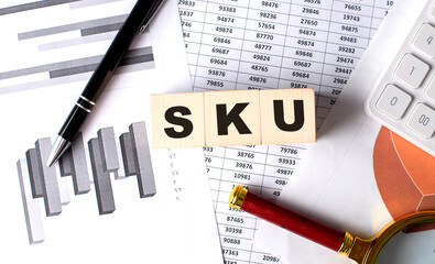 SKU Stock Keeping Unit text on wooden block on graph background with pen and magnifier