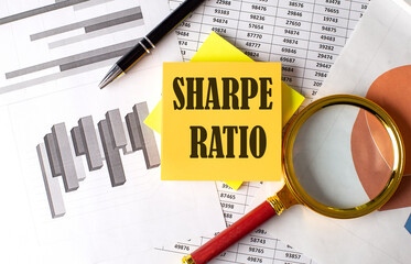 SHARPE RATIO text on a sticky on the graph background with pen and magnifier