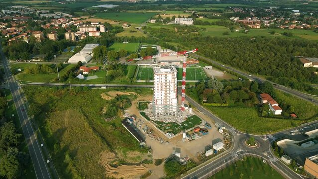 Crane for construction of residential Torre del Verde skyscraper in Vimercate, Brianza in Italy. Aerial tilt up reveal