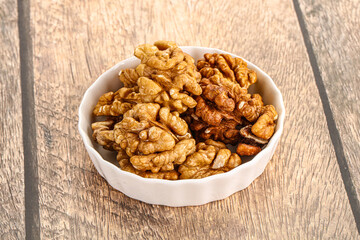 Cracked unshelled walnut in the bowl