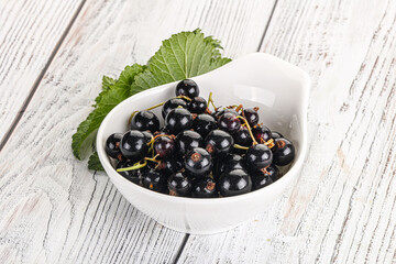 Juicy black currant berries in the bowl