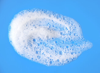white foam from soap isolated on a blue background