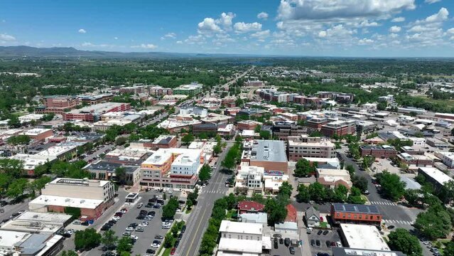 Ft. Collins, Colorado during summer. High aerial establishing shot. Beautiful orbit of housing and shops in downtown.