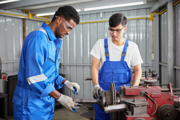 factory workers or technicians working and control lathe machine in factory