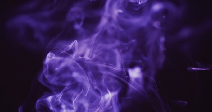 Video of purple clouds of smoke moving with copy space on black background