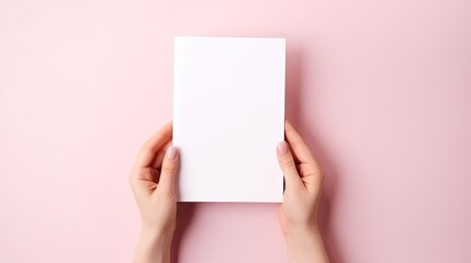 Woman s hands holding pink mockup notebook with small cactus on table