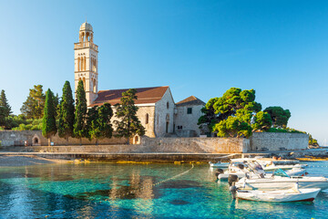 Turquoise water of Adriatic sea bay on Hvar island with franciscian monastery and boats in Dalmatia region, Croatia at sunrise - 637796322